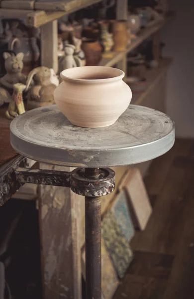 La cacerola de barro en primer plano y las baldas con la cerámica - en segundo lugar —  Fotos de Stock