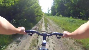 Yeşil bir ormanda bisiklet süren bisikletçi kız.