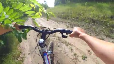 Ormandaki bir toprak yol üzerinde bir adam bir bisiklet sürmek