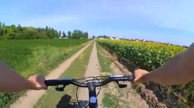 Bir alanı bir toprak yolda Bisiklete binmek bir adam