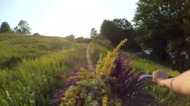 Ağır çekim. Kadın bir alan üzerinden bir bisiklet sürme