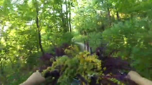 Dziewczyna jeździ na rowerze z bukietem kwiatów przed kołem — Wideo stockowe