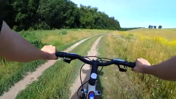 Человек на велосипеде едет по грунтовой дороге — стоковое видео