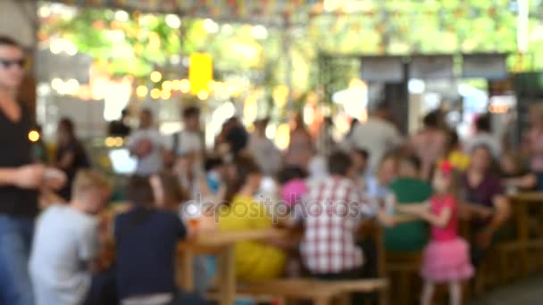 Многие люди сидят за столами и едят на фестивале — стоковое видео