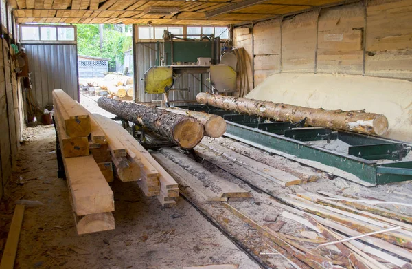 Un aserradero. Proceso de mecanizado de troncos en aserradero máquina sierra el tronco del árbol —  Fotos de Stock