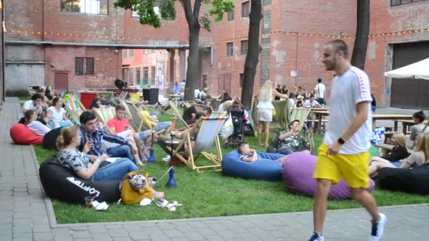 Festival straatvoedsel. Veel mensen zitten, relax rest op kleurrijke zetel-tassen. — Stockvideo