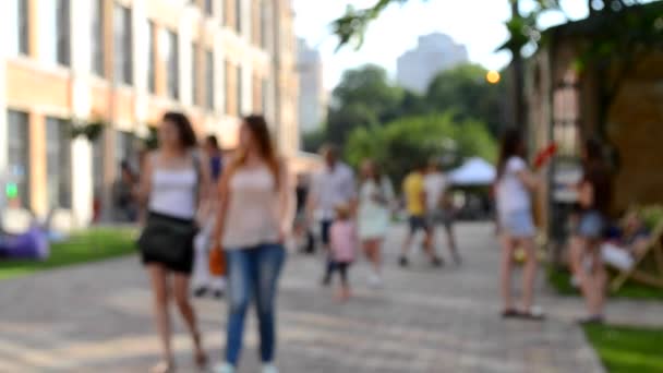 Menschen gehen die Straße entlang. Hintergrundunschärfe. — Stockvideo