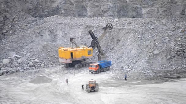 Huge yellow excavator loading stones into a truck — Stock Video