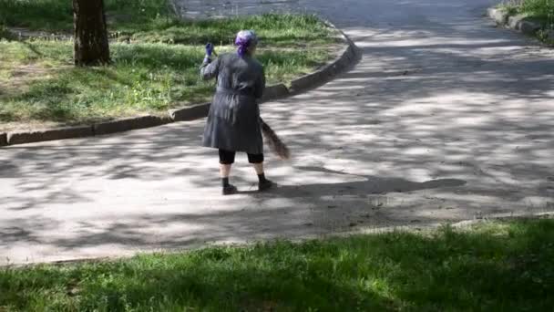 Woman cleaning woman sweeping the street with a broom in the morning — Stock Video