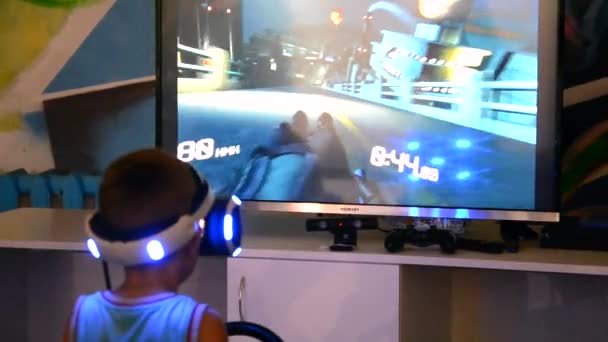 Niño en un casco de realidad virtual juega un juego de ordenador — Vídeo de stock