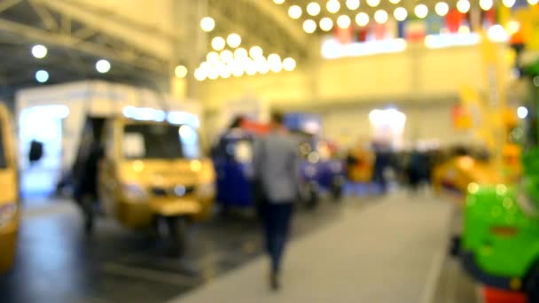 Beaucoup de camions de voitures camion à l'intérieur du pavillon d'exposition et les gens se promènent autour — Video