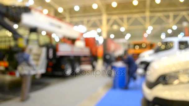 Molti camion auto camion all'interno del padiglione della mostra e la gente a piedi intorno — Video Stock