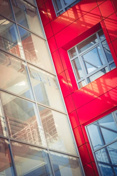 Fasad av ny modern byggnad med en genomskinlig del och röd vägg — Stockfoto