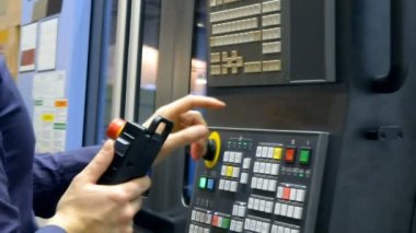 Kontrol panelinde çalışan adam endüstriyel bir makineyle çalışıyor.