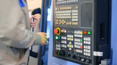 Kontrol panelinde çalışan adam endüstriyel bir makineyle çalışıyor.