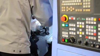 Kontrol panelinde çalışan adam endüstriyel bir makineyle çalışıyor.