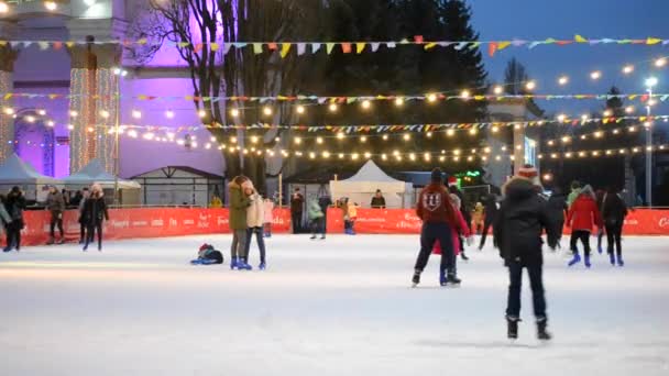 Ice rink with many people outdoors open by night. — Stock Video