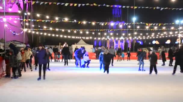 Ice rink with many people outdoors open by night. — Stock Video