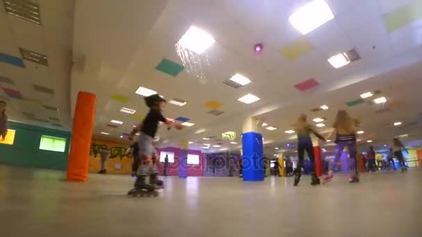 Muitas pessoas de crianças e adultos vão patinar no rollerdrom — Vídeo de Stock