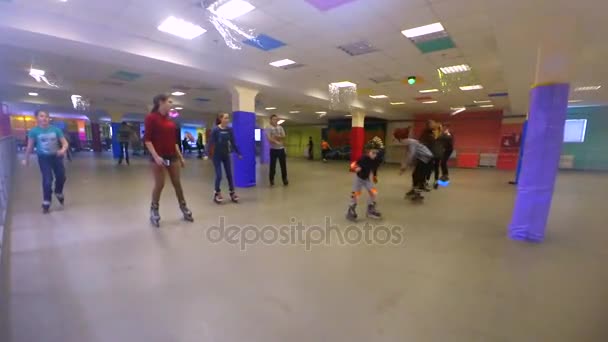 Beaucoup de gens d'enfants et d'adultes font du roller sur le rollerdrom — Video