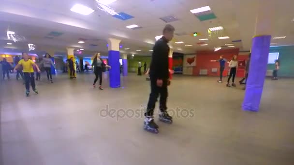 Many people of children and adults go roller-skating on the rollerdrom — Stock Video