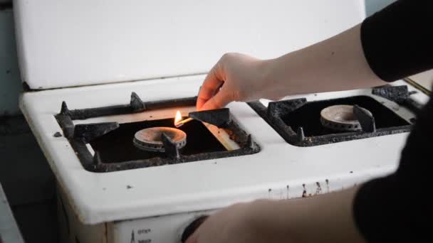 Женщина зажигает горелку на старой газовой плите деревянной спичкой — стоковое видео