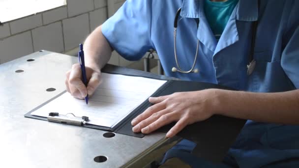Doctor masculino escribiendo un documento — Vídeo de stock