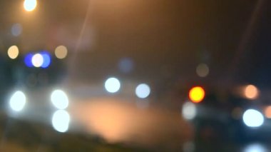 Arka plan otomobil sürücüsü şehrin ıslak bir yolda geceleri bulanık