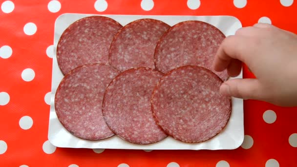 Person taking slices of smoked sausage. Close-up top view. — Stock Video