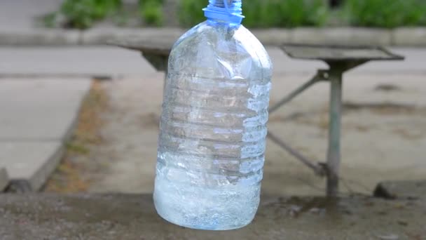 Vierta agua en una botella de plástico — Vídeo de stock