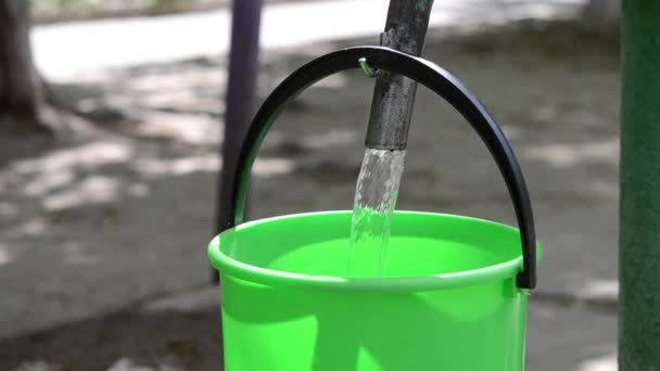 Ведро с водой и тряпкой. Приспособление для наливания воды из крана в ведро. Инвентарь для ручной стирки. Наливать воду в ведро. Кувшин с льющейся водой.