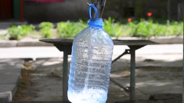 Wasser in eine Plastikflasche gießen — Stockvideo