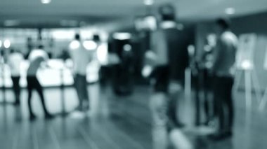 Bulanık arka plan. İnsanlar beyaz salonda tezgahın arkasında duruyorlar..