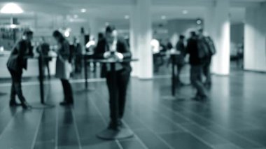 Bulanık arka plan. İnsanlar beyaz salonda tezgahın arkasında duruyorlar..