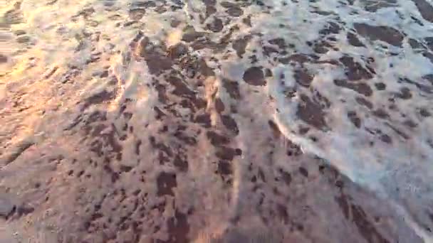 Ağır çekim. Beyaz köpüklü dalga deniz kumlu plaj rulo. — Stok video