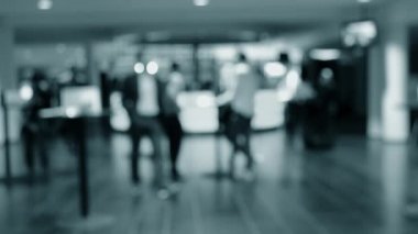 Bulanık arka plan. İnsanlar beyaz salonda tezgahın arkasında duruyorlar.