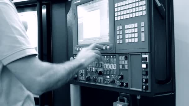Человек работает за панелью управления производственной машины — стоковое видео