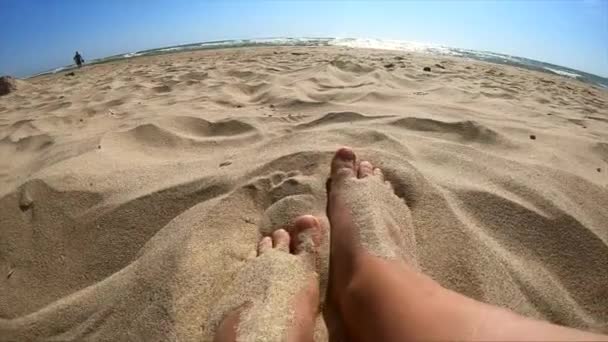 Duas pernas de uma menina caucasiana fêmea desfrutando de areia branca em uma praia de areia — Vídeo de Stock