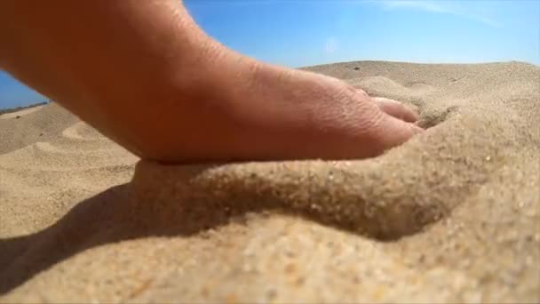 Slow motion. Girl picks up handful of sand in her palm and sprinkles — Stock Video