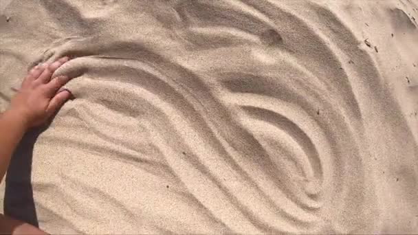 Pohyb rukou na povrchu písku, pohled shora. Mans hand scatters — Stock video