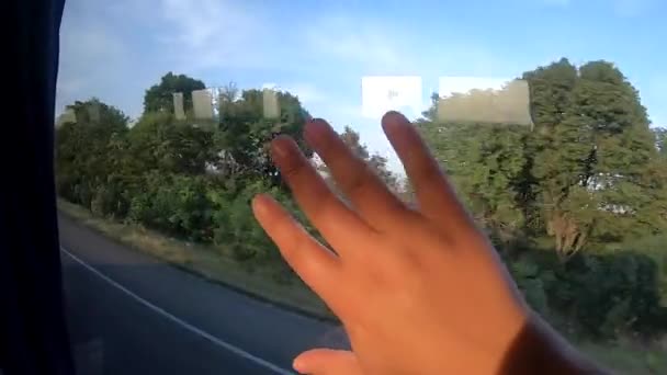 Hareket halindeki otobüsün pencere manzarası ve kızların eli camın üzerinde.. — Stok video