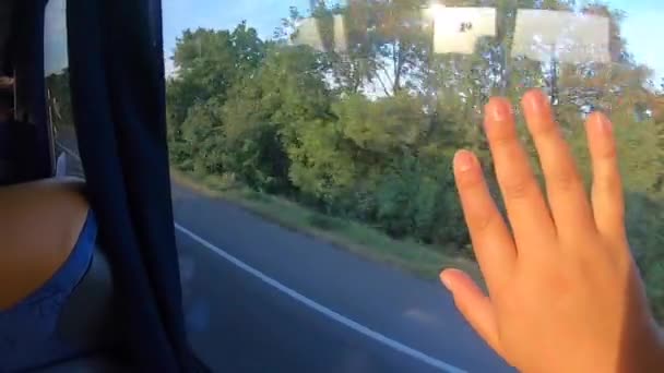 Ventana vista de autobús en movimiento y las niñas mano descansa sobre el vidrio . — Vídeo de stock