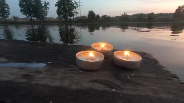 三支药丸蜡烛放在一个旧木板码头的边缘上 — 图库视频影像