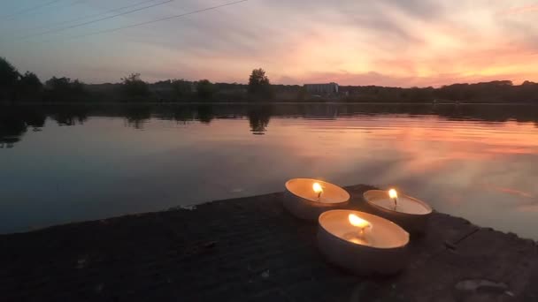 Trois bougies de pilule reposent sur le bord d'un vieux quai de planche en bois — Video