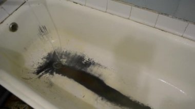 Çok eski, paslı, pejmürde bir banyo.