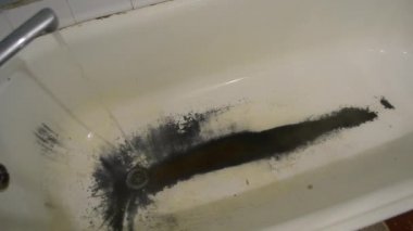 Çok eski, paslı, pejmürde bir banyo.