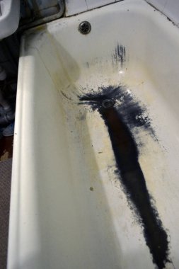 Çok eski paslı, paslı bir banyo. Yakın plan. Kabuğu soyulmuş beyaz bir banyo.