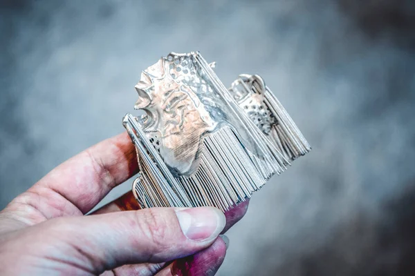 Мужчина держит в руках предмет, напечатанный на металлическом 3D принтере. — стоковое фото