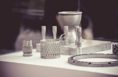 Metal 3D yazıcıya yazdırılmış nesneyi tutan adam.