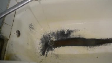 Çok eski, paslı, pejmürde bir banyo.
